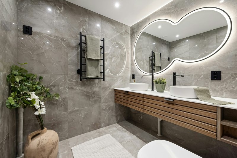 Marble-tiled bathroom with a wooden vanity
